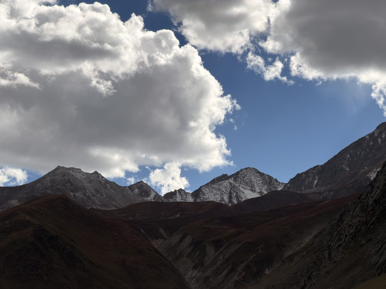 Dark mountains under towering clouds